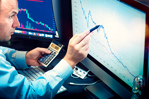 Stockbroker analyzes the financial chart. Online stock exchange on a computer monitor